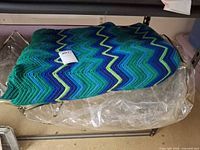 Full view of folded crochet blanket on shelf