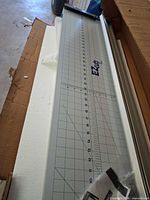 Full view of EZcuts cutter in box showing gridded surface and rail