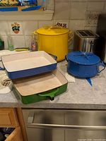 Group shot showing yellow pot, blue pot, and two rectangular casseroles