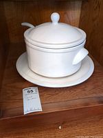 Overall view of soup tureen on platter with ladle