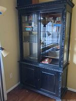 Full view of cabinet showing glass doors, shelving, lower storage