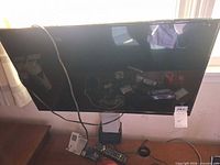 Front view of Element TV on stand with remote visible