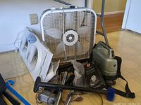 Group shot of box fan, window fan, Hoover vacuum, attachments and bag pack