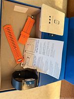 Tracker, orange replacement band pieces, manuals inside box