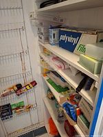 Shelving unit with various food wrap boxes, trash bags, cleaners and sponges