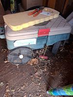 Garden cart with kneeling pad and pruners visible