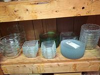 Shelf with multiple glass bowls, dishes and vase