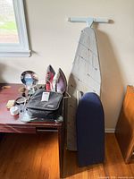 Lot overview showing irons, boards, clipper case, mirror, scale and brush