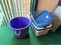 Purple utility bucket, blue tote with lid, stacked white laundry baskets