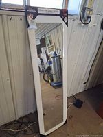 Front view of white-framed full-length mirror with packaging header