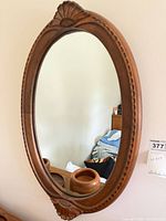 full view of oval wood mirror on wall