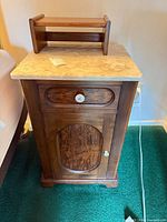 Front view of nightstand with marble top and small shelf placed on top