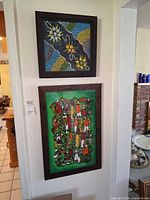 Both framed paintings hung on wall