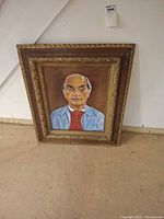 Full view of framed portrait painting leaning against wall