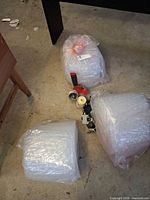 Three bags of bubble wrap and three tape dispensers on concrete floor