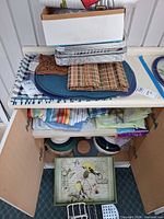 Cabinet with placemats, aluminum trays, textiles and bird tray