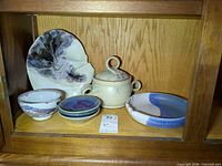 Group view of all pottery pieces on shelf