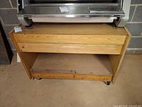 Front view of wooden rolling cart with open shelf