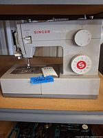 Front view of Singer Heavy Duty sewing machine showing branding, stitch dial, and presser foot area