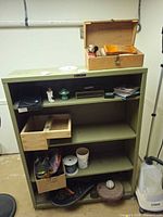 Overall view showing shoecare box, CDs, figurines, weights and hardware on shelving