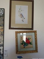 Both framed silk artworks on wall