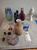 overview of all vases, tin, pouch, ornament, figurine, stones on tabletop