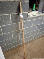 Full view of walking stick leaning against wall