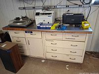 Front view of metal cabinet showing top, drawers, door, and handles