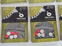Front view of two sealed Preciosa packs showing red and clear crystals
