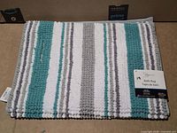 Folded rug showing stripe pattern and texture with manufacturer tag