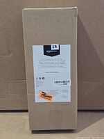 Sealed Amazon Basics box containing plastic drying rack with two mats