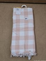 Folded set of three check tea towels with product tag showing item 39 sticker