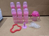 Full lot showing six bottles, sippy cup, teether, purple stand, bag of parts