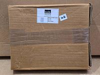 Sealed cardboard box with BIDK Home label containing photo frame