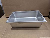 Oblique view of stainless steel steam pan showing exterior and depth