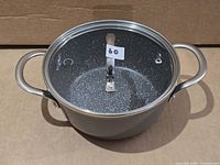 Saucepot with lid in place showing handles, lid, and speckled interior through glass