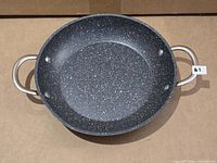 Top view of speckled non-stick frying pan showing interior and handles