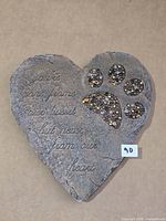 Full view of heart-shaped memorial stone showing inscription and paw print