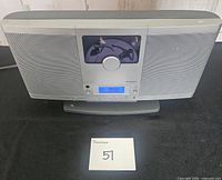 Front view of Brookstone AM/FM CD player showing speakers, control knob, display