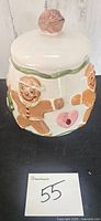 Front view of ceramic cookie jar showing gingerbread men and lid
