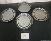Four pans: three fluted Tiara pans, one Calphalon cake pan