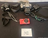 Overview of all items: Fujifilm S700, Canon Rebel with lens, red compact camera, Canon charger