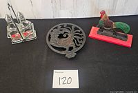 Full lot view: cruet set, cast iron trivet, rooster nutcracker