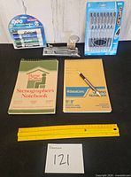 All items laid out: marker pack, pen pack, stapler, two notebooks, rulers, pen