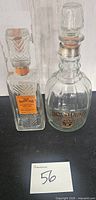 Front view of both vintage liquor bottles showing Jack Daniels No.7 decanter and square cut-glass whiskey bottle