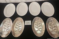 Top row four white ceramic Tree of Life platters, bottom row four matching metal sizzle plates