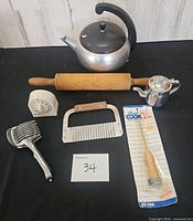 All kitchen items laid out including kettle, teapot, rolling pin, timer, pastry blender, crinkle cutter, packaged ice pick