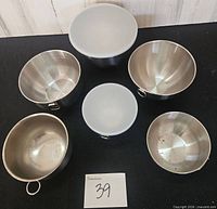 Six stainless steel bowls, two with lids, top view