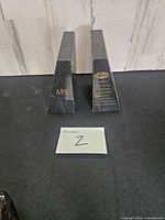 Front view of two black marble bookends showing gold inscriptions