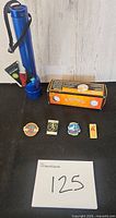 Full lot view showing flashlight, Callaway golf balls sleeve and four Olympic pins